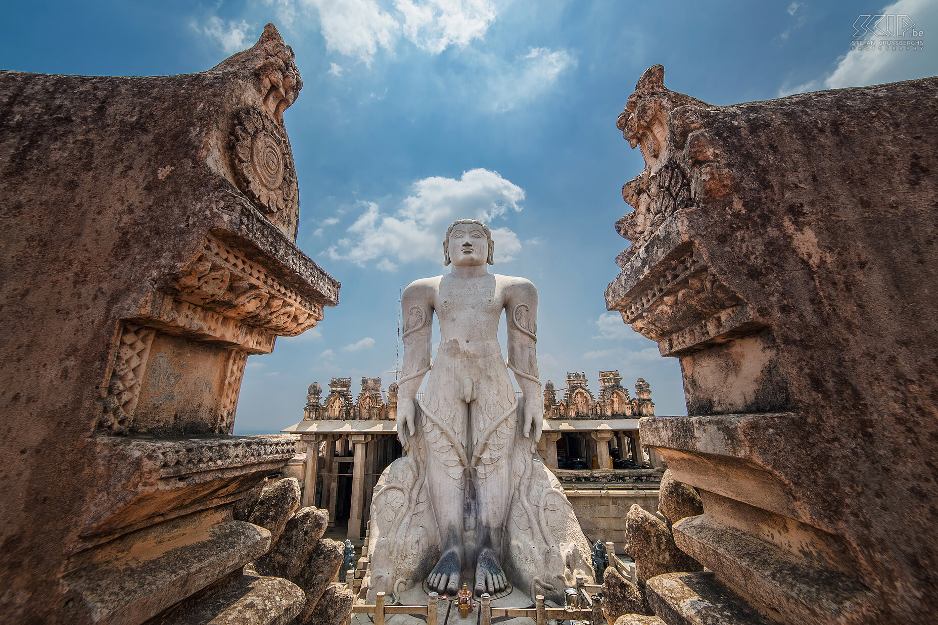 Shravanabelagola - Bahubali Op de top van de Vindyagiri heuvel in Shravanabelagola staat er een kolosaal wit standbeeld van Gommateshvara Bahubali. Het is 17 meter hoog en het wordt beschouwd als 's werelds grootste monolithische stenen beeld. Het is gebeeldhouwd in 981 na Christus. Bahubali was de zoon van Rishabhanatha, de eerste Tirthankara (religieuze leraar) van het Jaïnisme. Hij zou een jaar lang in staande houding roerloos hebben gemediteerd. Elke twaalf jaar is er een spectaculaire ceremonie en duizenden devote Jains offeren dan rijst, suikerriet, sandelhout, saffraan, bloemen, ...  Stefan Cruysberghs